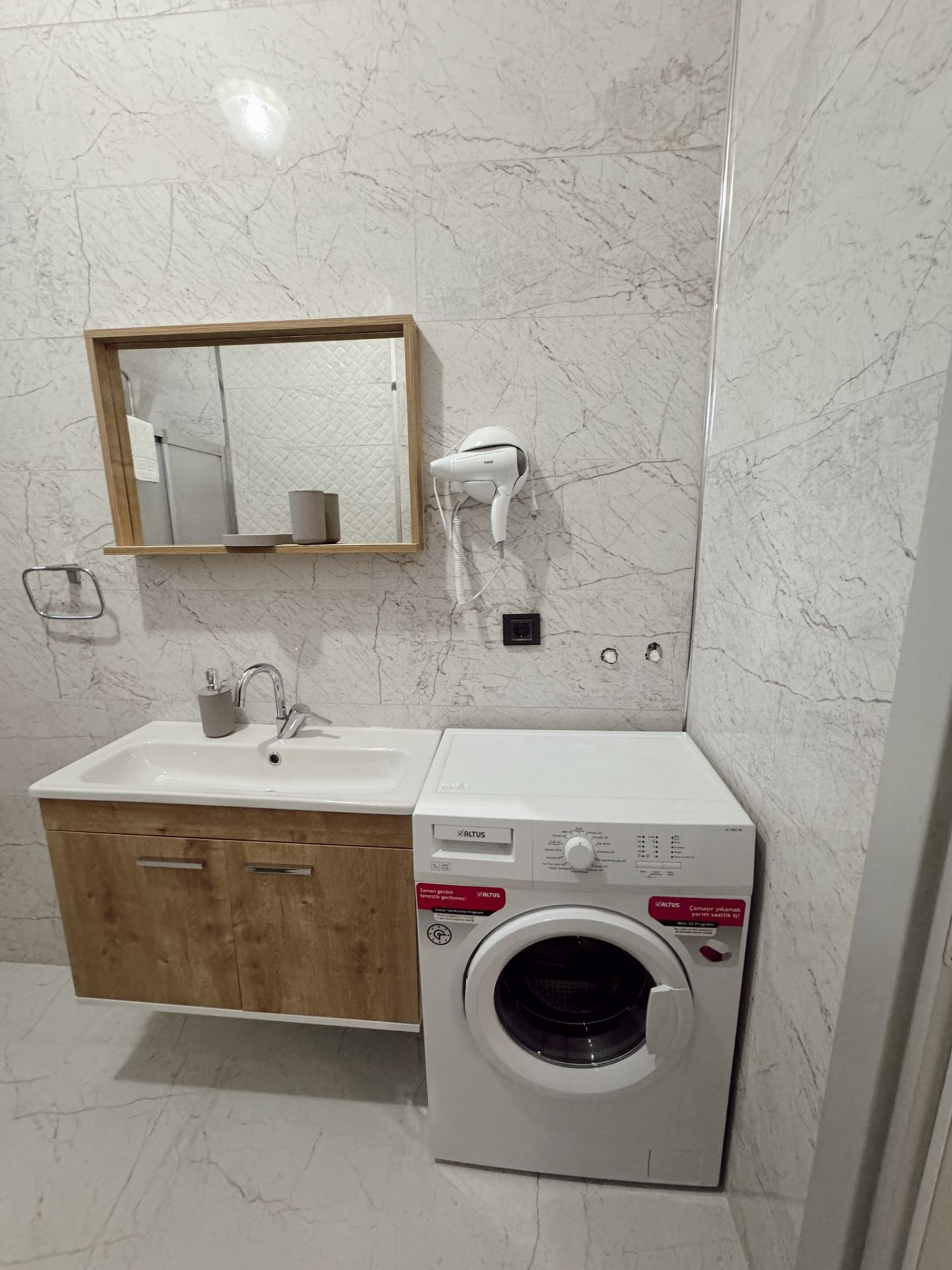 Banyoda lavabo, ayna ve çamaşır makinesi