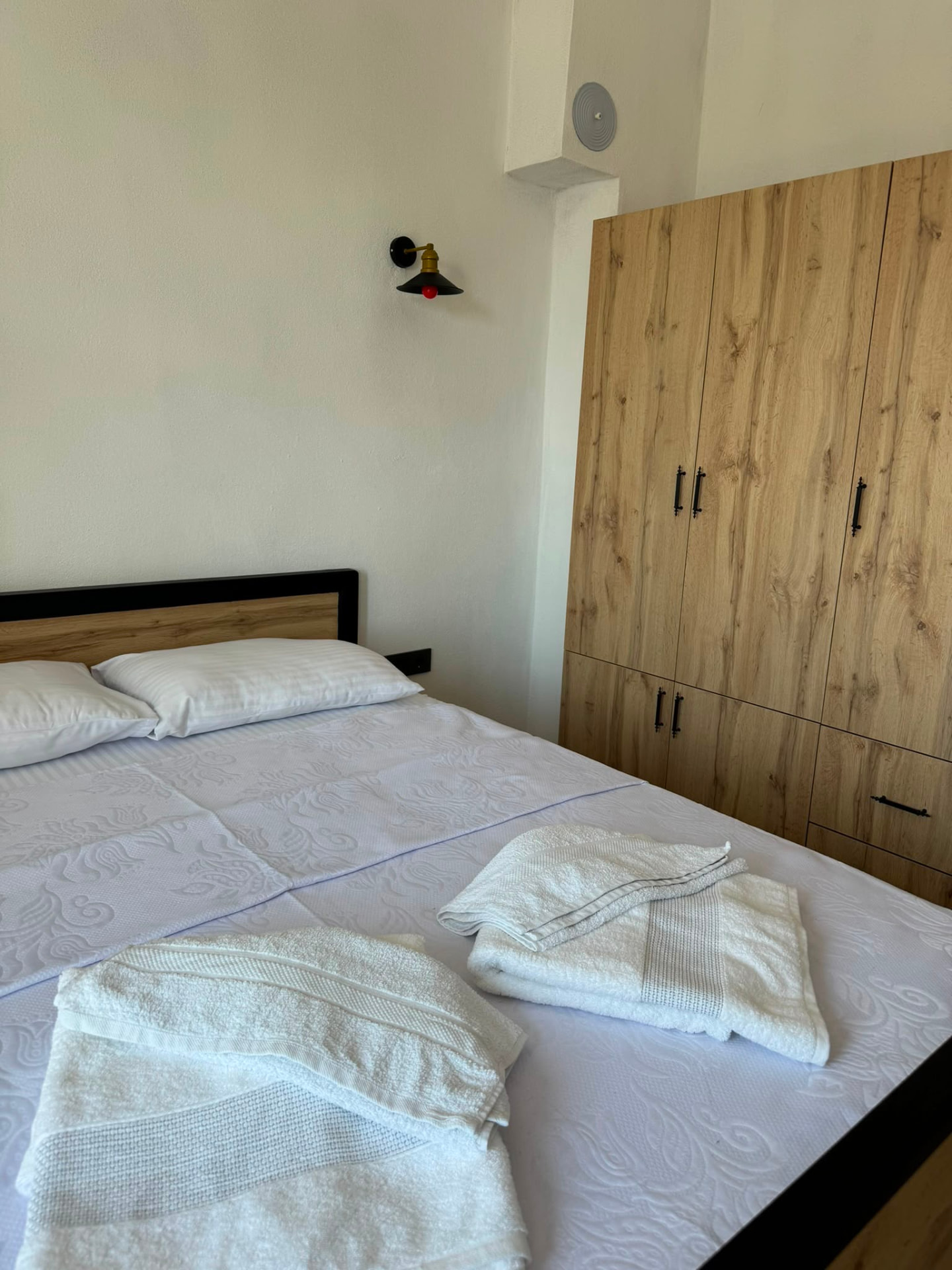 Suit yatak odası; ahşap-siyah karyola, beyaz nevresim ve ahşap gardırop
